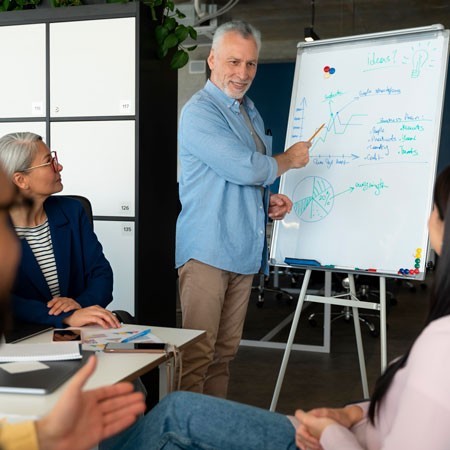 Un emprendedor sénior está reunido con su equipo y le muestra el balance de las facturas que el equipo de Cobrogestión ha cobrado